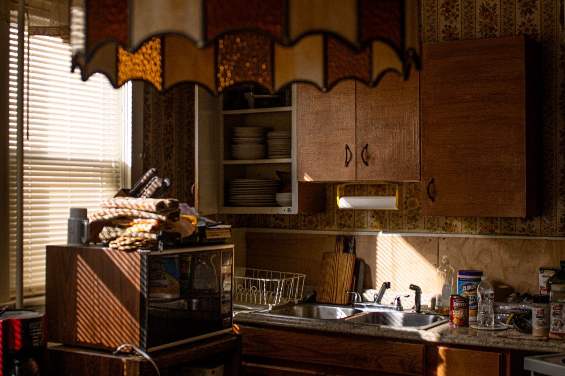 Tired kitchen with dark dated timber cabinets before refinishing