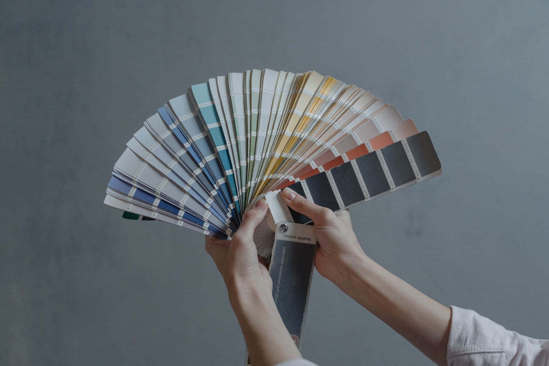 Color Consultation by Brivon — Colour specialist holding an open paint swatch fan