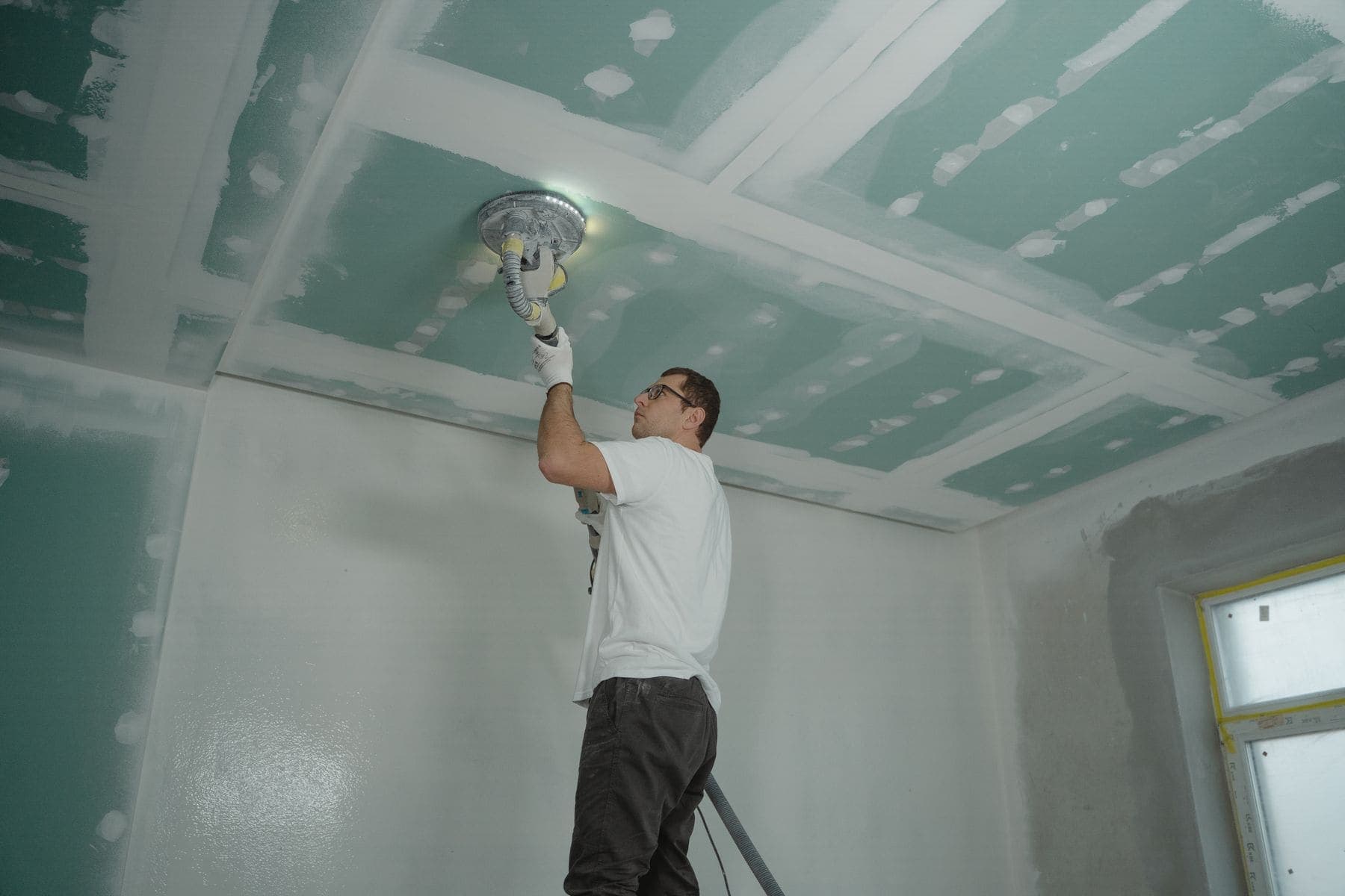 Ceiling being sanded smooth ahead of repainting