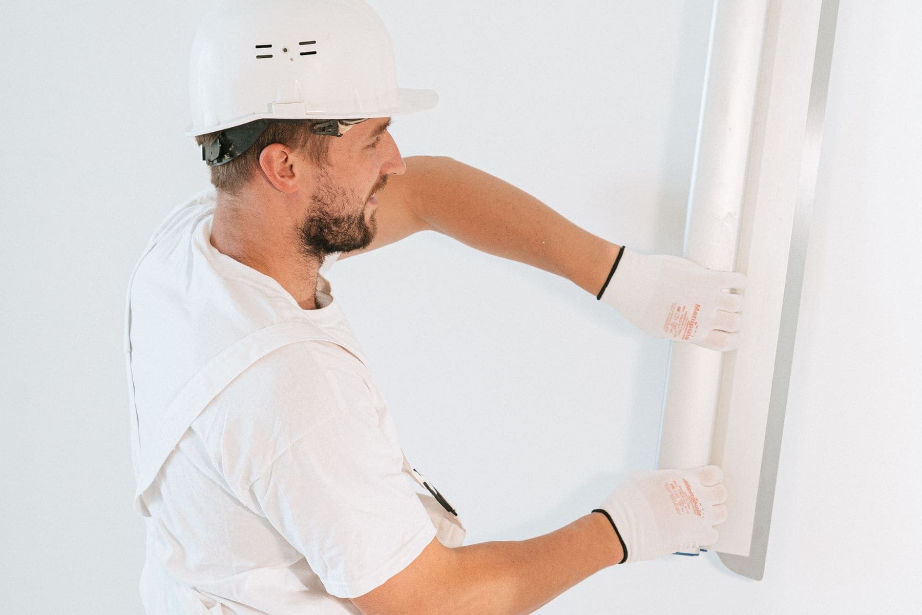 Drywall Repair by Brivon — Tradesperson smoothing a wall ready for its first coat