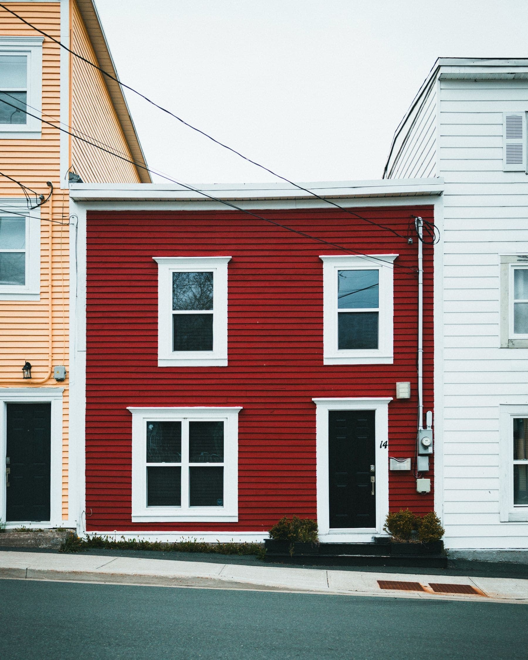 Coastal cottage with freshly painted red and white weatherboard cladding