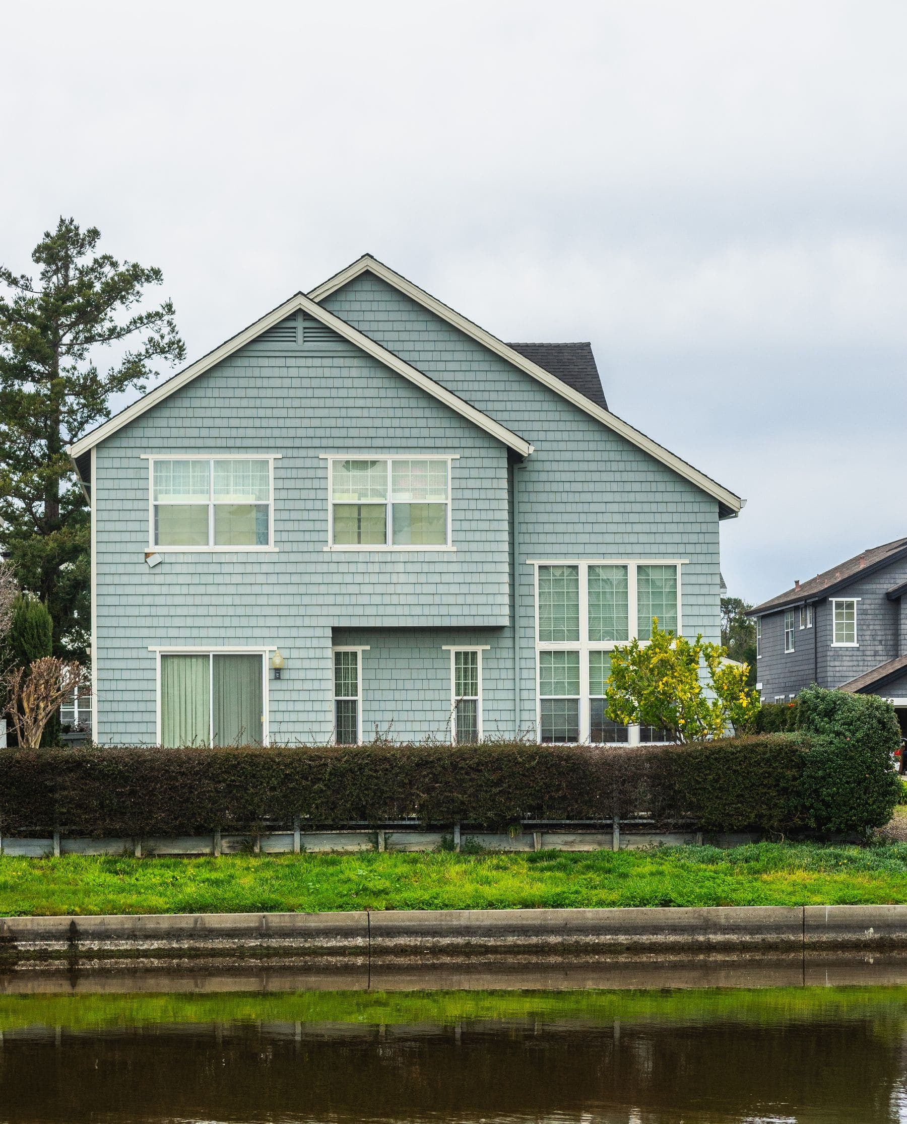 Suburban two-storey house with pale blue painted siding