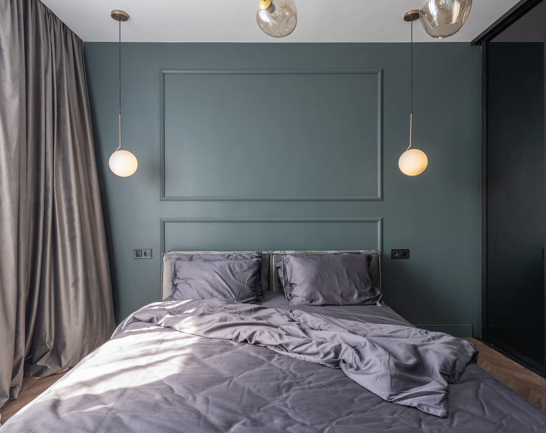 Bedroom with a calm sage-green painted feature wall