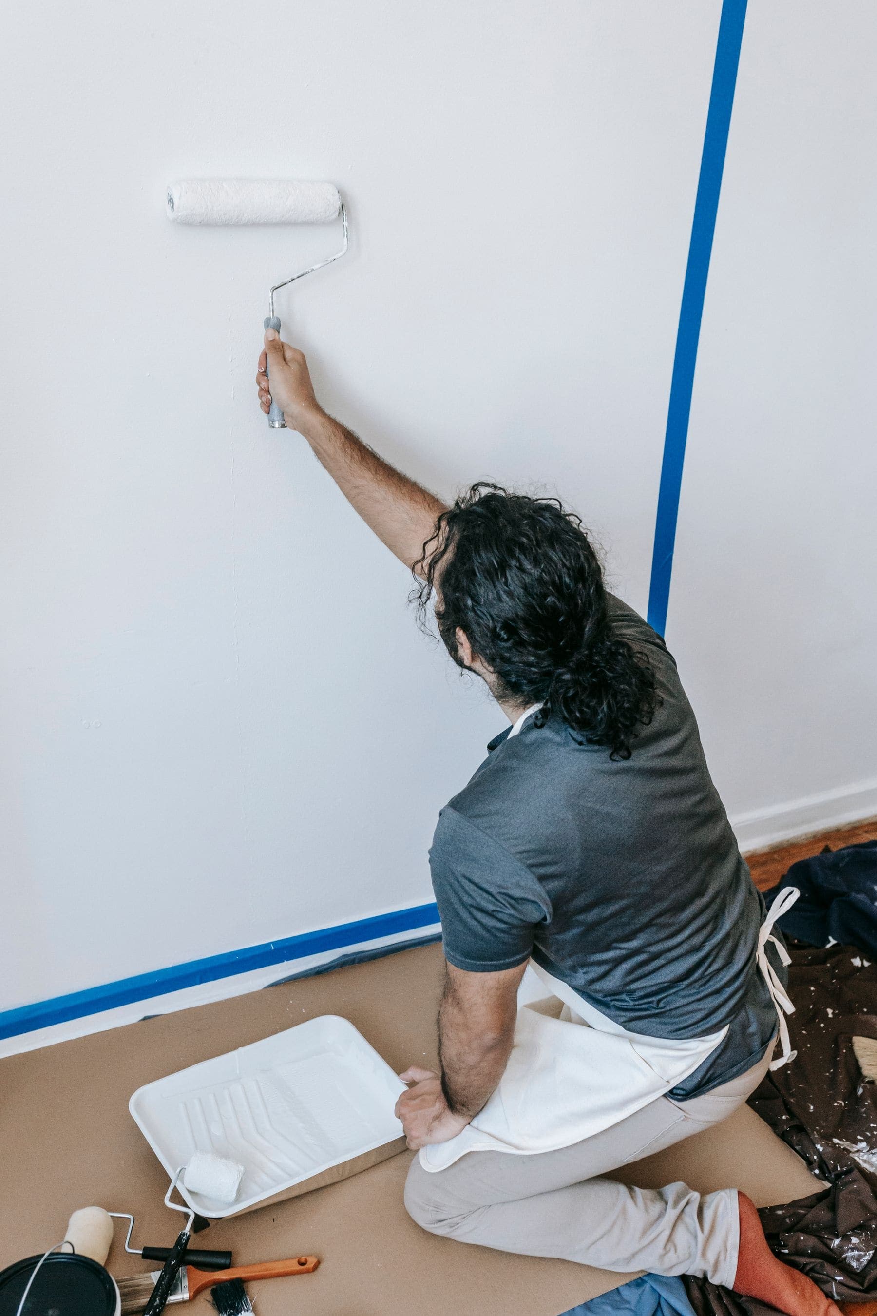 Painter cutting in a sharp line against masking tape on interior trim