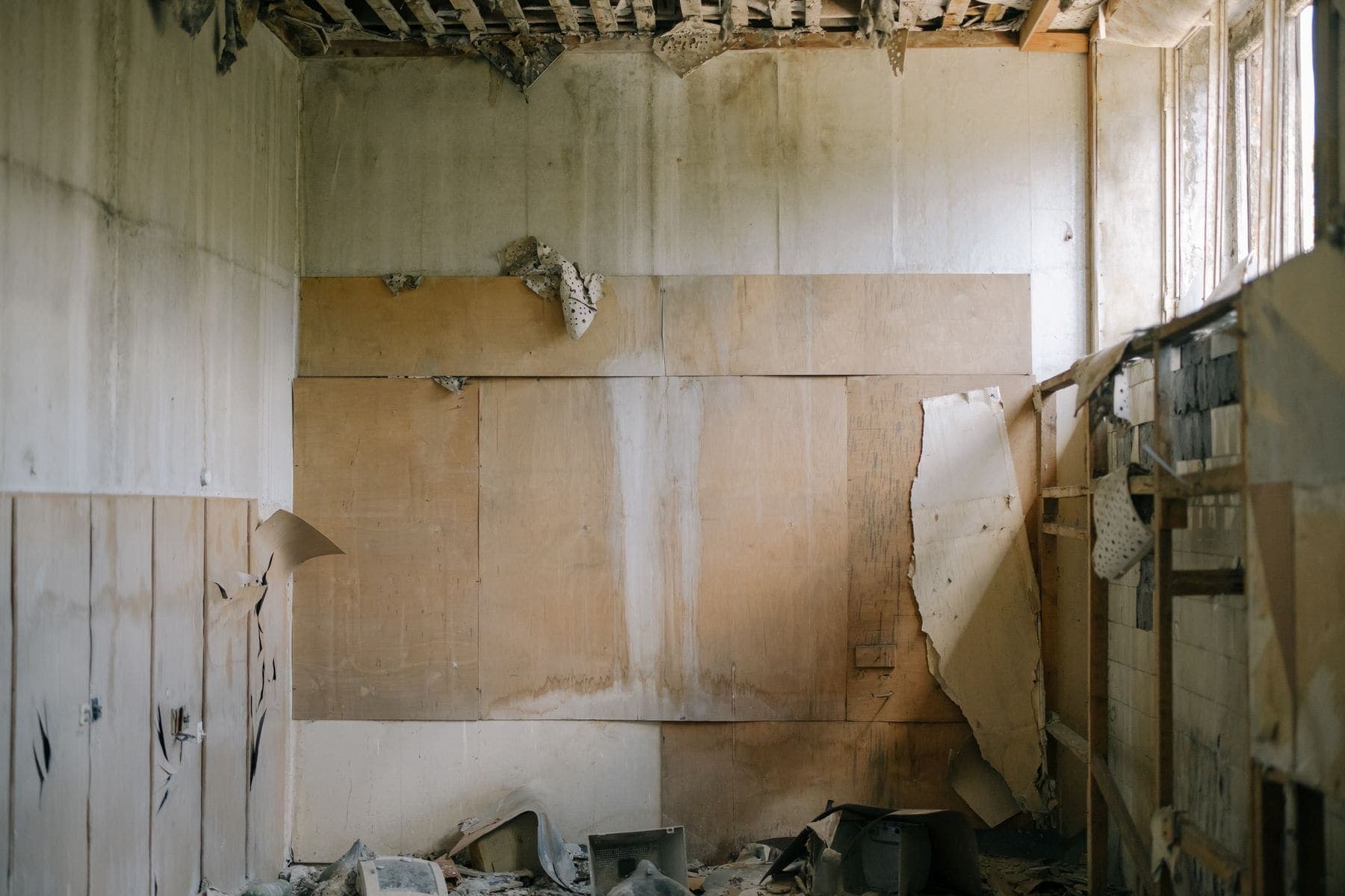 Old wall covering being stripped back inside a room